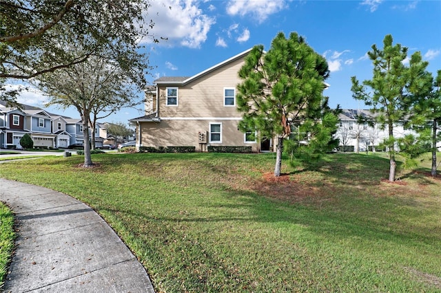 view of side of property featuring a yard, a residential view, and stucco siding