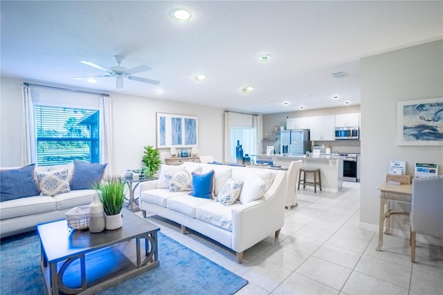 living area with light tile patterned floors, ceiling fan, visible vents, and recessed lighting