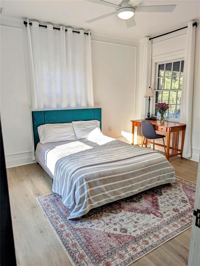 bedroom featuring wood finished floors, a ceiling fan, and baseboards