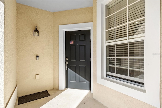 entrance to property with stucco siding