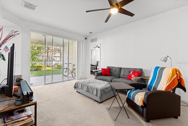 living area with visible vents, carpet flooring, and a ceiling fan