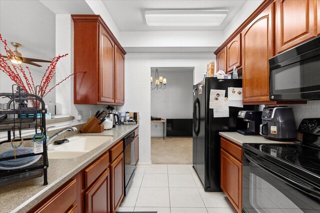 kitchen featuring light tile patterned floors, brown cabinetry, a sink, black appliances, and ceiling fan with notable chandelier