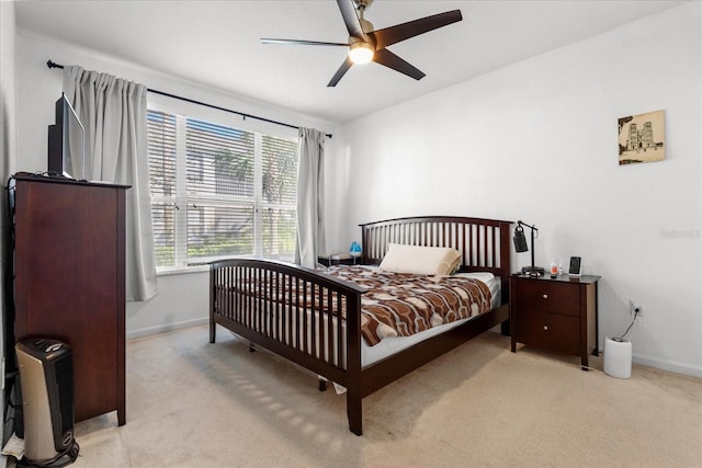 bedroom featuring baseboards, a ceiling fan, and light colored carpet