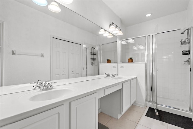 bathroom with double vanity, tile patterned flooring, a shower stall, and a sink