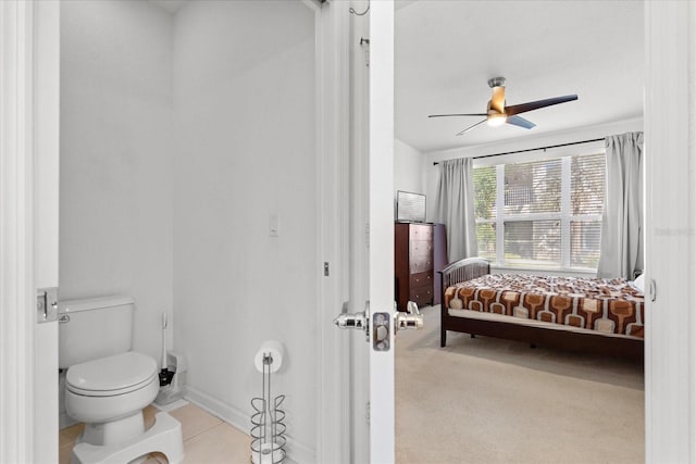 bathroom with baseboards, toilet, and a ceiling fan