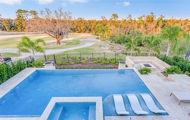 pool featuring an in ground hot tub, a patio area, and a fenced backyard