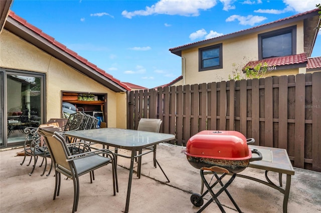 view of patio featuring outdoor dining area and fence