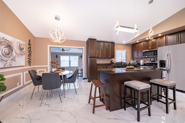 kitchen with marble finish floor, stainless steel appliances, a breakfast bar, and dark brown cabinetry