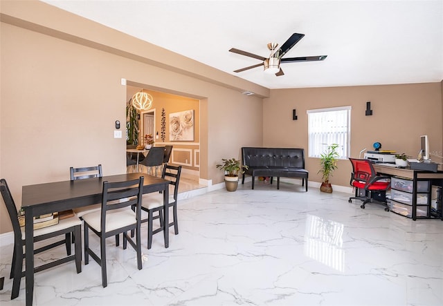 dining room with marble finish floor, baseboards, and a ceiling fan