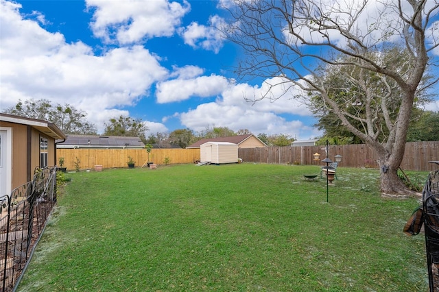 view of yard with an outbuilding, a fenced backyard, and a storage shed