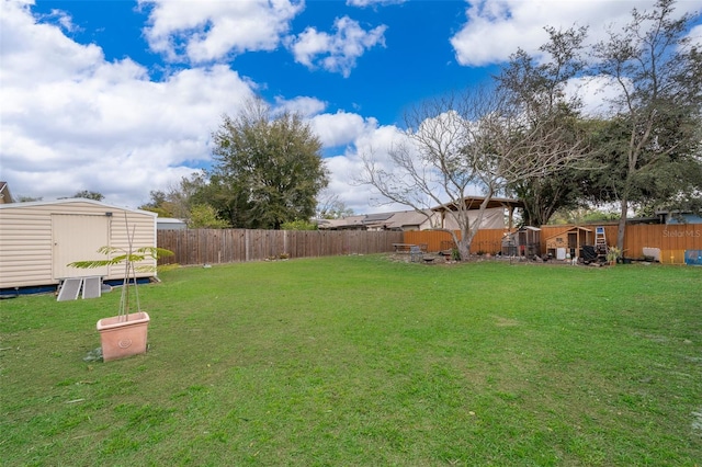 view of yard with an outbuilding, a fenced backyard, and a storage unit