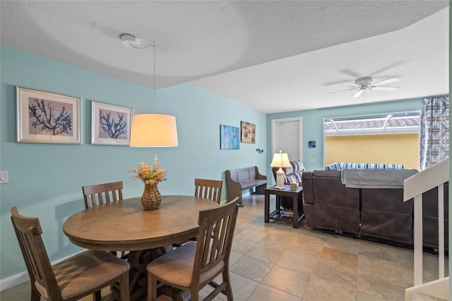 dining room with a textured ceiling, baseboards, and a ceiling fan