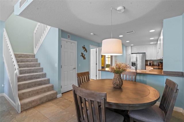 dining space featuring stairs, visible vents, a textured ceiling, and recessed lighting