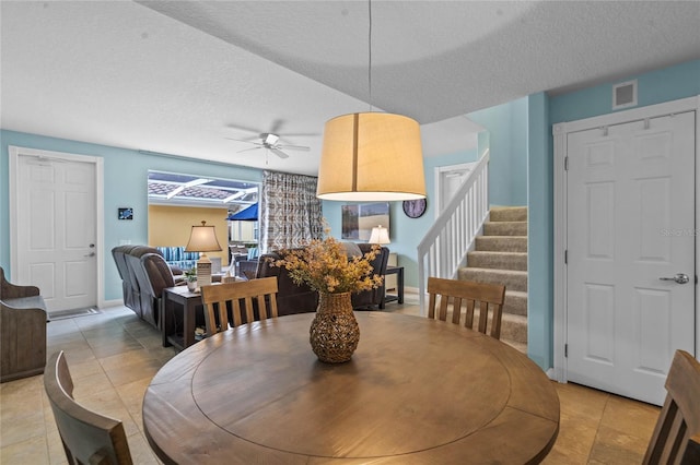 dining space featuring light tile patterned floors, stairway, a textured ceiling, and visible vents