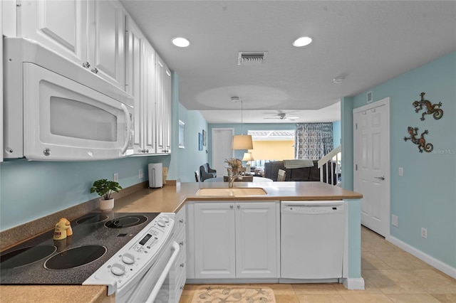 kitchen with white cabinetry, a sink, ceiling fan, white appliances, and a peninsula