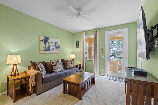 carpeted living room featuring baseboards and a ceiling fan