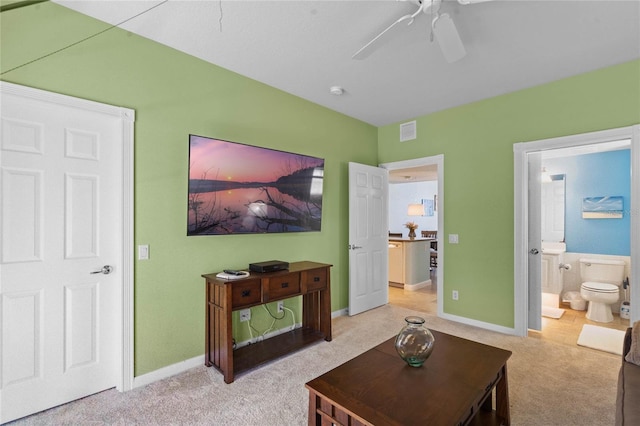 living area featuring light carpet, a ceiling fan, visible vents, and baseboards