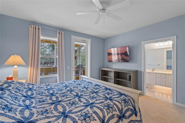 carpeted bedroom featuring ensuite bath, a sink, a ceiling fan, and access to exterior