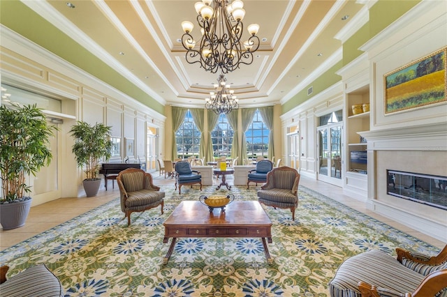 interior space with built in features, a premium fireplace, a tray ceiling, crown molding, and a notable chandelier