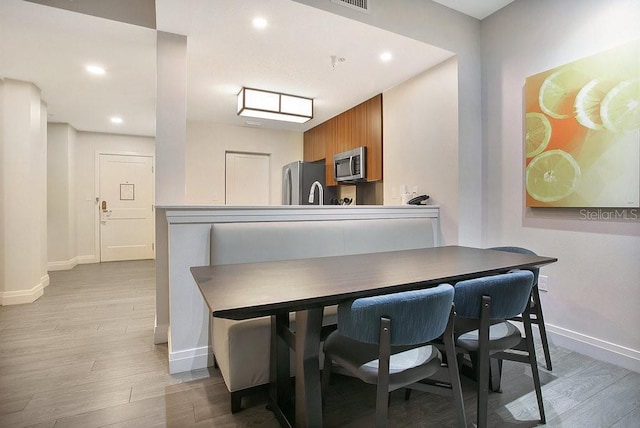 dining room featuring light wood-style flooring, visible vents, baseboards, and recessed lighting