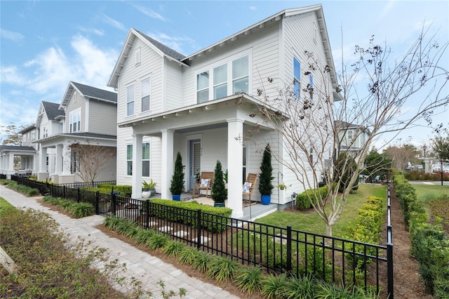 view of front of house featuring covered porch, a fenced front yard, and a front yard