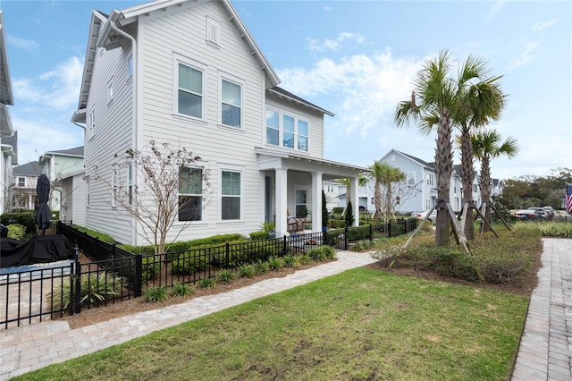 traditional-style house featuring a fenced front yard and a front yard