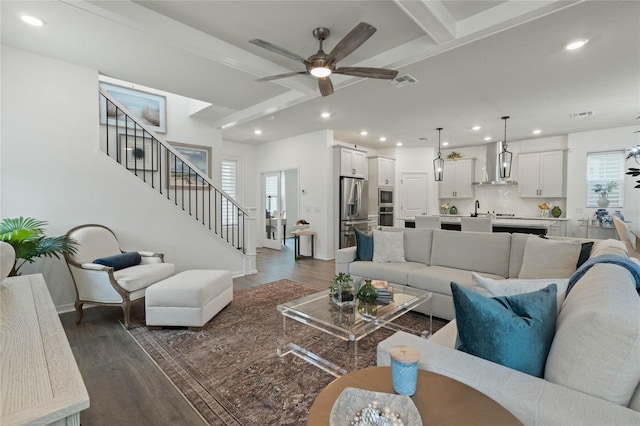 living room featuring beamed ceiling, stairway, dark wood-style flooring, and recessed lighting