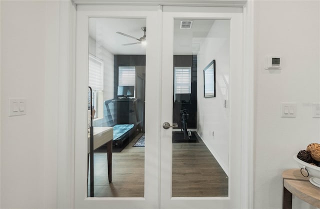 hall with french doors, visible vents, and wood finished floors