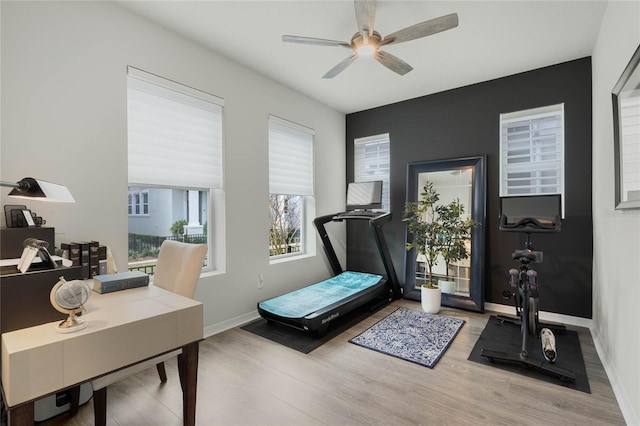 workout area featuring a ceiling fan, baseboards, and wood finished floors