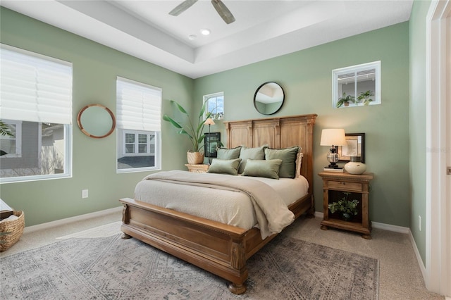 carpeted bedroom featuring a tray ceiling, recessed lighting, a ceiling fan, and baseboards