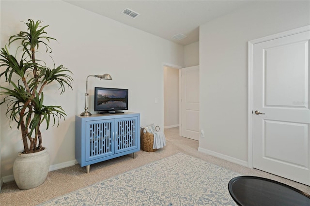 sitting room with carpet floors, visible vents, and baseboards