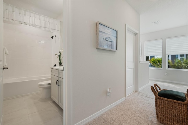 interior space with tile patterned flooring, visible vents, bathing tub / shower combination, vanity, and baseboards