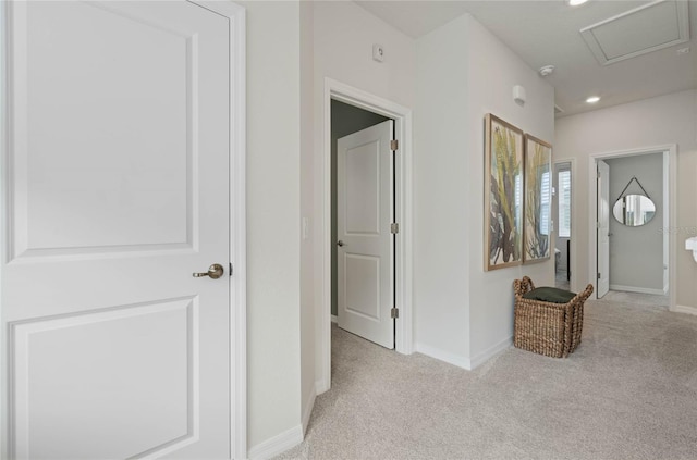 hall featuring carpet floors, attic access, and baseboards