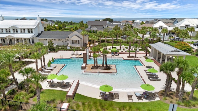 community pool with a residential view, fence, and a patio