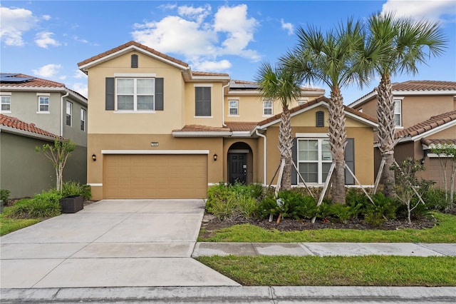 mediterranean / spanish-style home featuring a garage, solar panels, a tiled roof, and stucco siding