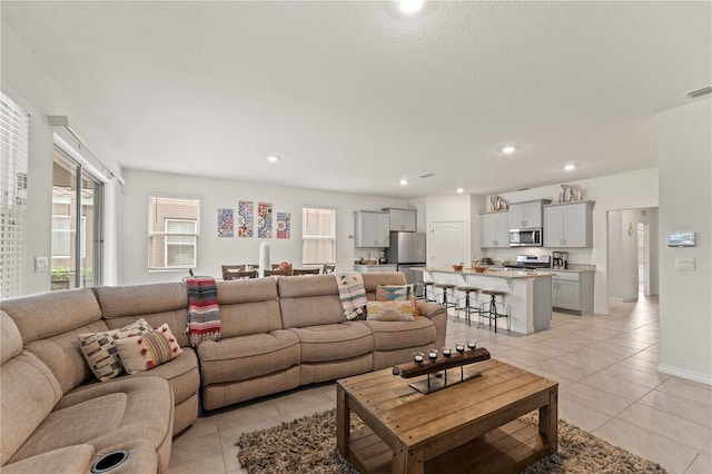 living room featuring baseboards, visible vents, recessed lighting, and light tile patterned floors