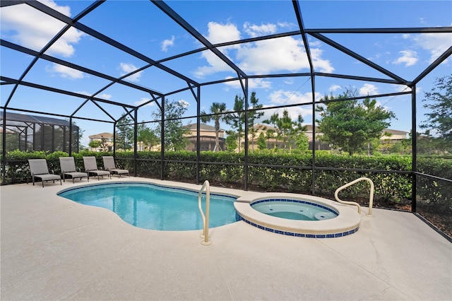 view of swimming pool featuring a patio area, a lanai, and a pool with connected hot tub
