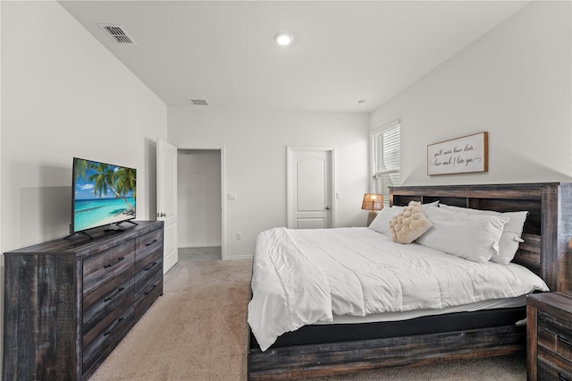 bedroom with baseboards, visible vents, and light colored carpet