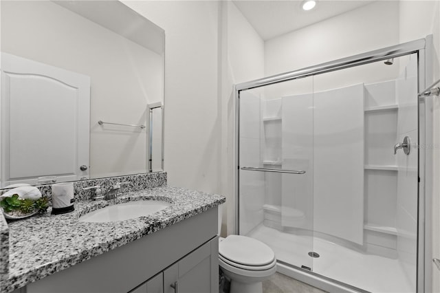 bathroom with toilet, vanity, and a stall shower
