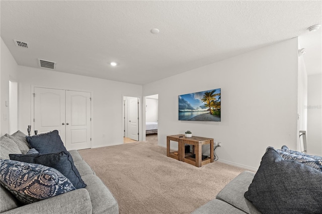 carpeted living room with baseboards, visible vents, and recessed lighting