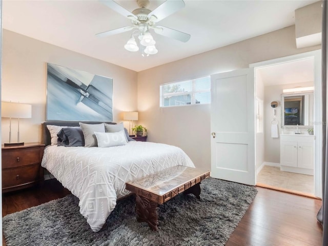 bedroom featuring ceiling fan, a sink, wood finished floors, and baseboards