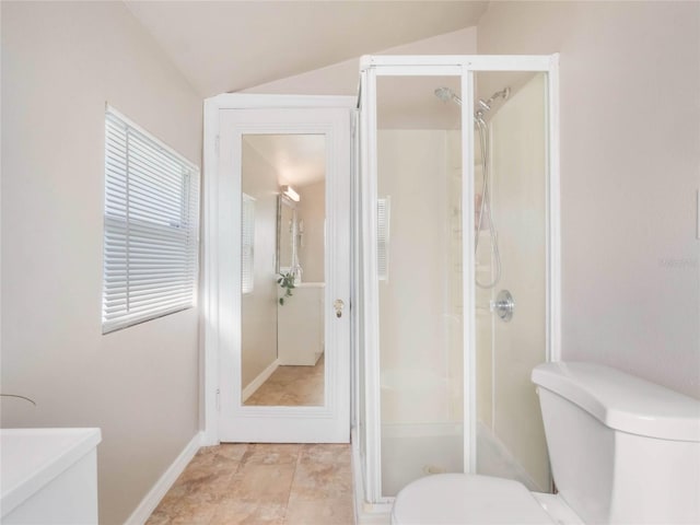 bathroom featuring a stall shower, baseboards, vaulted ceiling, and toilet