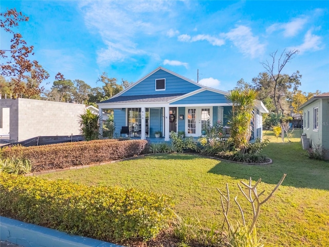 view of front of house with a front yard, covered porch, and fence