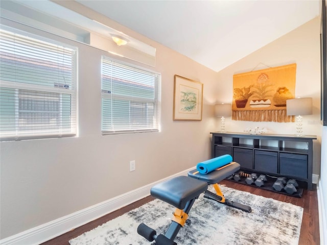 workout area with lofted ceiling, wood finished floors, and baseboards