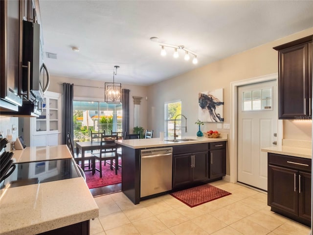 kitchen with appliances with stainless steel finishes, a peninsula, dark brown cabinets, pendant lighting, and a sink