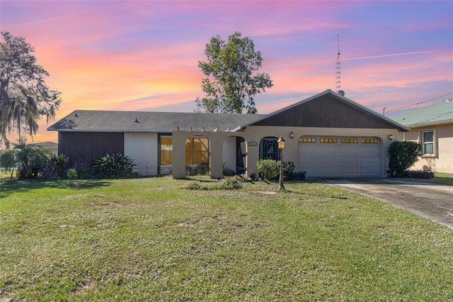 view of front of house featuring a garage, a yard, and concrete driveway