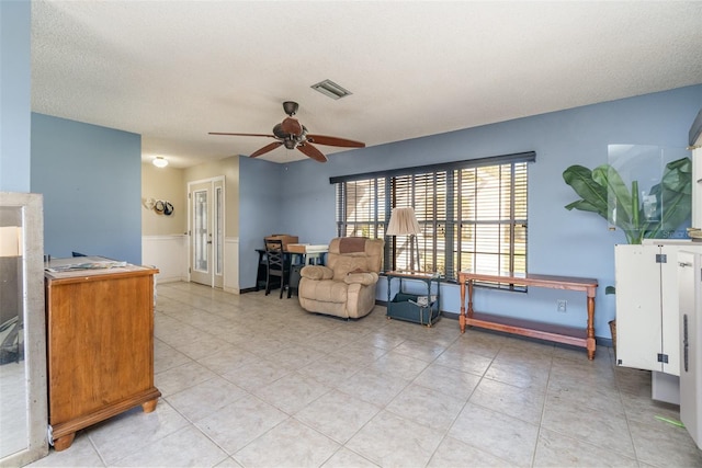 sitting room with ceiling fan, light tile patterned floors, a textured ceiling, and visible vents