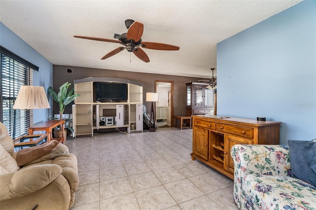 living area featuring ceiling fan, a textured ceiling, and light tile patterned floors