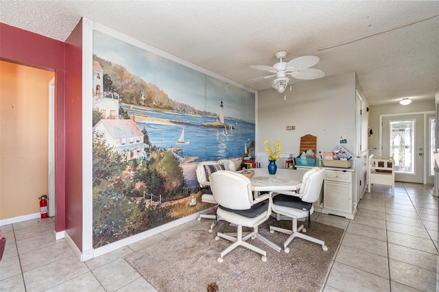 dining area featuring light tile patterned floors, ceiling fan, a textured ceiling, and baseboards