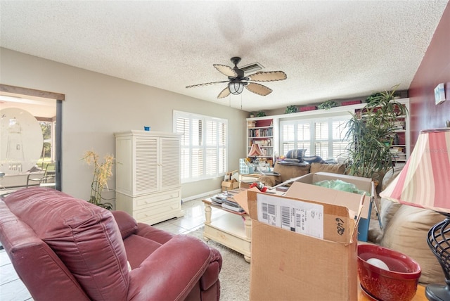 tiled living area with a textured ceiling and a ceiling fan